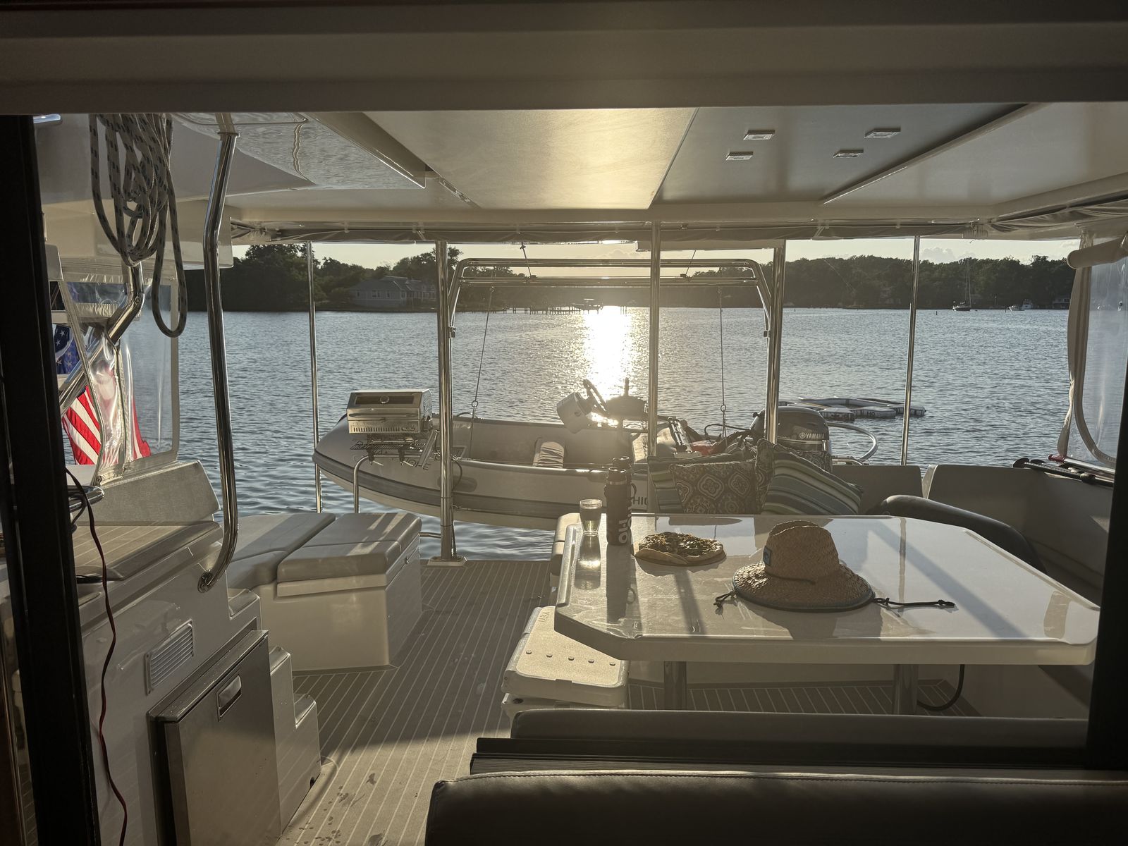 Saloon looking aft at sunset, PlasDeck L-settee, grill, dinghy on davits