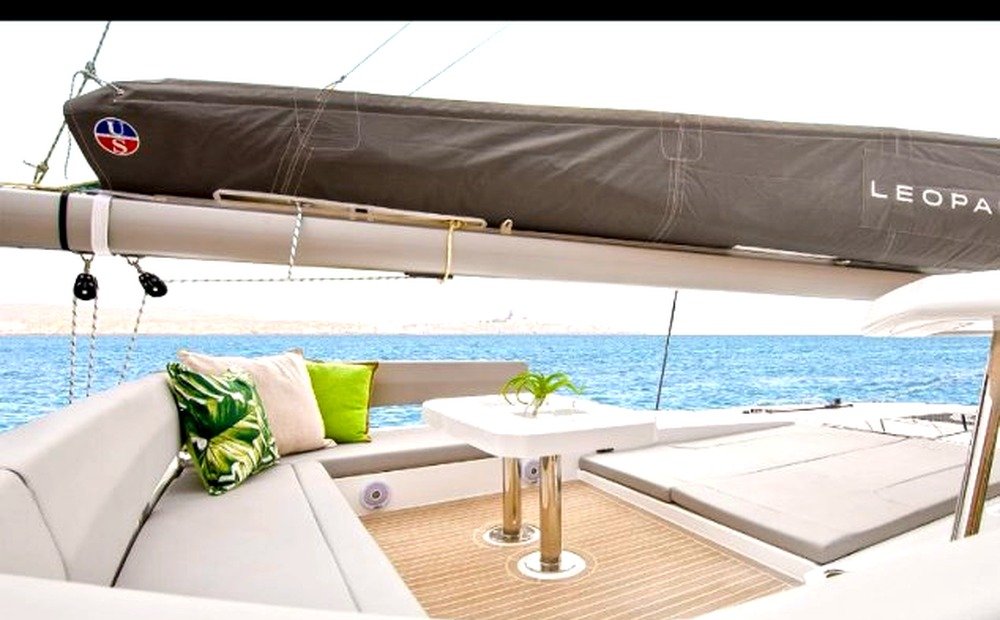Coachroof flybridge lounge with grey cushions, white table, and LEOPARD 45 boom cover, empty